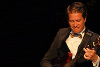 <strong>Patrick Schenkius</strong> - Orkestleider/gitaar en banjo<br /><p>Patrick Schenkius&nbsp;is de orkestleider&nbsp;van 'Tour de Toon'.&nbsp;Tevens speelt hij in het programma&nbsp;gitaar en banjo.&nbsp;Patrick studeerde af aan het Koninklijk Conservatorium in Den Haag bij gitarist Peter Nieuwerf.&nbsp;Daarna voltooide hij&nbsp;zijn studie muziektheorie lichte muziek aan het Hilversums Conservatorium.&nbsp;Patrick arrangeerde&nbsp;de liedjes&nbsp;voor&nbsp;'Tour de Toon'.&nbsp;Daarbij is&nbsp;consequent de&nbsp;oorspronkelijke stijl en vorm&nbsp;aangehouden zoals Toon Hermans&nbsp;de liedjes&nbsp;in zijn shows&nbsp;heeft gezongen.&nbsp;Zo komen de originele klankkleur en 'sound' van&nbsp;de&nbsp;composities&nbsp;van Toon&nbsp;Hermans&nbsp;weer volledig tot&nbsp;hun recht.</p>
<p>Een enorme klus die Patrick met verve heeft verricht.</p>